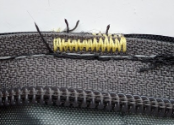 A temporary basting stitch holding two pieces of fabric together.
